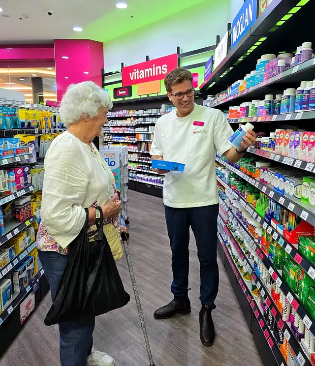 Jason Markey helping a customer choose a vitamin in the aisle at Priceline Pharmacy Pacific Fair